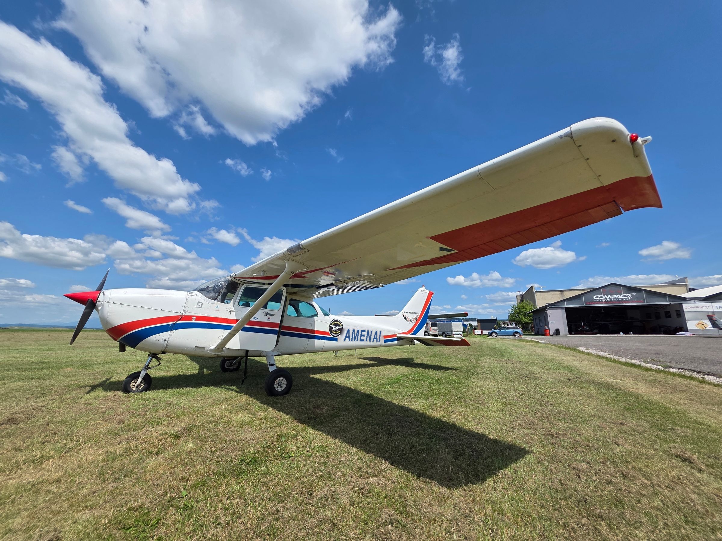 Cessna in amenai colors in front of a hangar